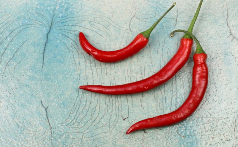 three red chili on gray surface